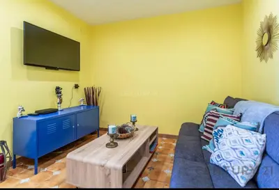 a living room with a blue couch and a tv at Charming Coastal Retreat in Alboraya