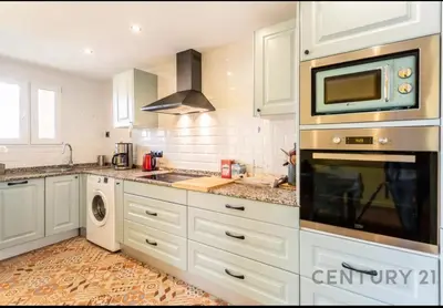 a kitchen with white cabinets and a microwave at Charming Coastal Retreat in Alboraya