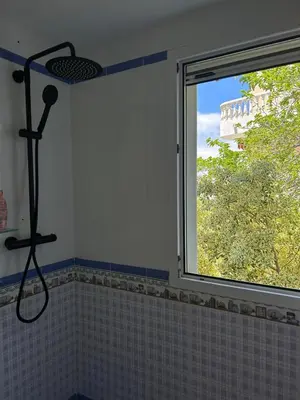 a shower in a bathroom with a window at Vila 
