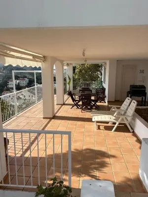 a patio with chairs and a table on a deck at Vila 