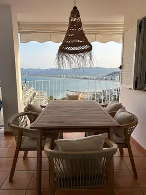 a dining room table with chairs and a view of the ocean at Vila 