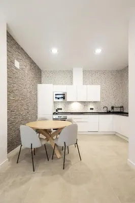 a kitchen with a wooden table and two chairs at Arm Suites by Concept Flats in Valencia