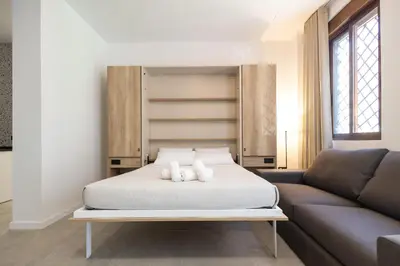 a bedroom with a bed and a couch at Arm Suites by Concept Flats in Valencia