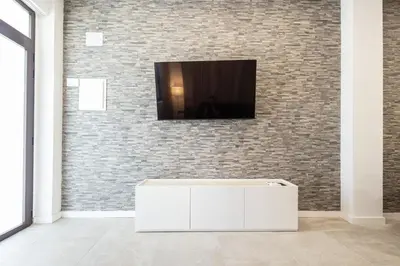 a living room with a tv on a brick wall at Arm Suites by Concept Flats in Valencia