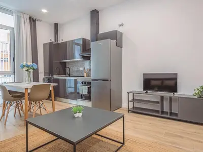 a large kitchen with a table and a refrigerator at Winahost Apartamento Benimaclet 1 in Valencia