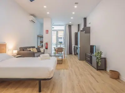 a bedroom with a bed and a living room at Winahost Apartamento Benimaclet 1 in Valencia
