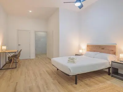a bedroom with a bed and a desk and a chair at Winahost Apartamento Benimaclet 1 in Valencia