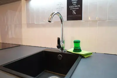 a kitchen sink with a faucet and a green cup at Premium & Céntrico in Valencia
