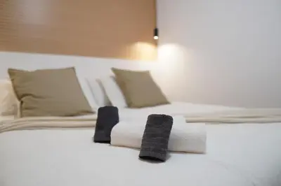 a white bed with towels and pillows on it at Premium & Céntrico in Valencia