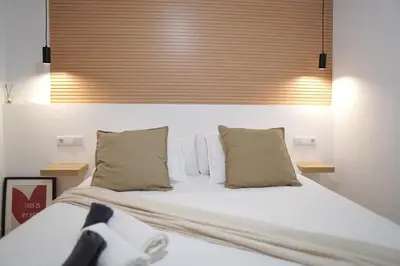 a bedroom with a bed with white sheets and pillows at Premium & Céntrico in Valencia