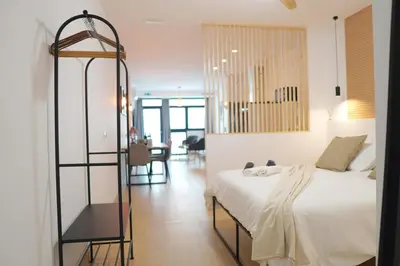 a bedroom with a white bed and a dining room at Premium & Céntrico in Valencia