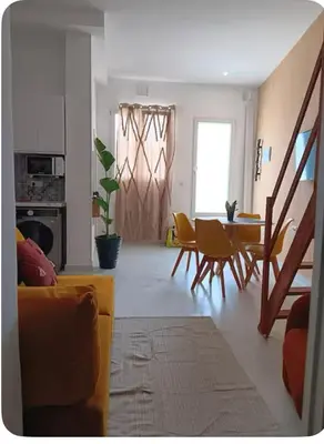 a living room with a couch and a table and chairs at Sueños en la playa in Valencia