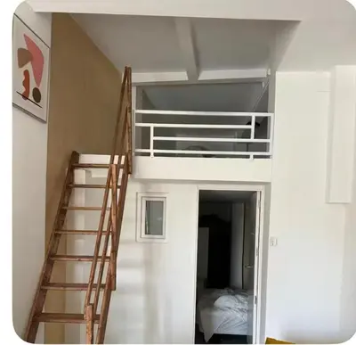 a room with a bunk bed and a ladder at Sueños en la playa in Valencia