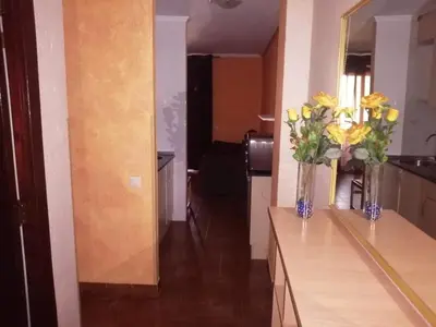 a vase of yellow flowers on a counter in a room at Apartamento en el faro de Cullera in Cullera