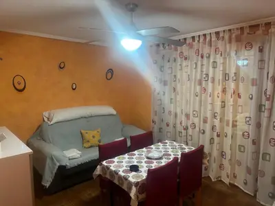 a room with a table and a bed and a ceiling fan at Apartamento en el faro de Cullera in Cullera