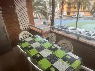 a table and chairs on a balcony with a view of a pool at Apartamento en el faro de Cullera in Cullera