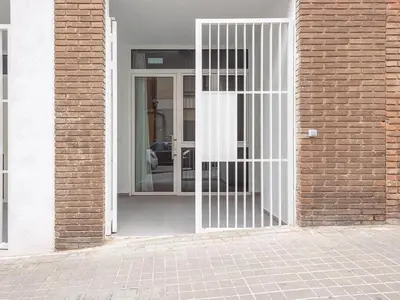 a white door with a gate in a brick building at Central Apartment in Benimaclet 2 in Valencia