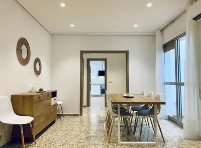 a dining room with a wooden table and chairs at Acogedora casa familiar de 4 habitaciones y gran terraza a metros de la playa in Puerto de Sagunto