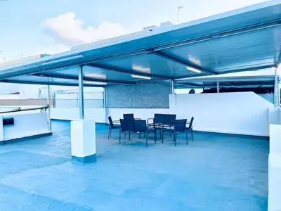 a patio with chairs and a table on a roof at Acogedora casa familiar de 4 habitaciones y gran terraza a metros de la playa in Puerto de Sagunto