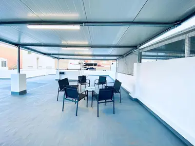 a room with a table and chairs in a building at Acogedora casa familiar de 4 habitaciones y gran terraza a metros de la playa in Puerto de Sagunto