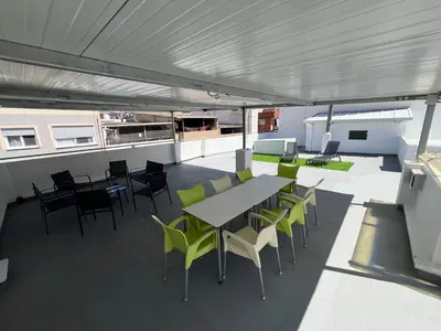 a patio with a table and chairs on a roof at Acogedora casa familiar de 4 habitaciones y gran terraza a metros de la playa in Puerto de Sagunto