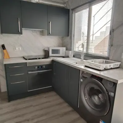 a kitchen with a washing machine and a microwave at Piso A playa 19 in Puerto de Sagunto