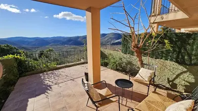 a patio with chairs and a table with mountains in the background at Casa Rural Torás Piscina, BBQ, Chimenea y WiFi 600Mb in Torás