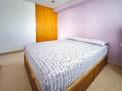 a bedroom with a bed with a white comforter at Apartamento con terraza en Playa Grau de Moncofa in Moncófar