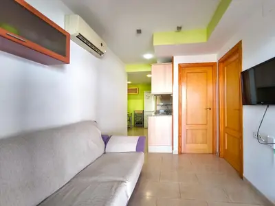 a living room with a couch and a flat screen tv at Apartamento con terraza en Playa Grau de Moncofa in Moncófar