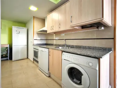 a kitchen with a washing machine and a sink at Apartamento con terraza en Playa Grau de Moncofa in Moncófar