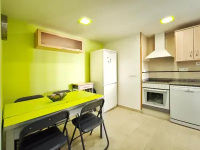 a small kitchen with a yellow table and chairs at Apartamento con terraza en Playa Grau de Moncofa in Moncófar