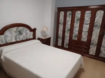 a bedroom with a bed and a large wooden headboard at Lorea Puerto in Puerto de Sagunto