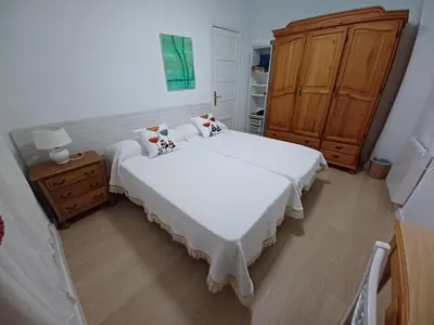 a bedroom with two beds and a wooden cabinet at Lorea Puerto in Puerto de Sagunto