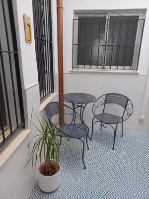 a patio with tables and chairs and a potted plant at Lorea Puerto in Puerto de Sagunto