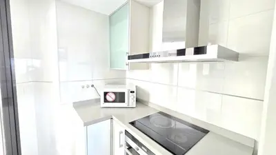 a white kitchen with a stove and a microwave at BEACH VALENCIA LUXURY D9-28 Apartment with terrace and sea views with two rooms in Valencia