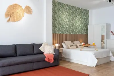 a living room with a couch and a bed at Loft Familiar: Paz y Conexión Ideal en Valencia in Valencia