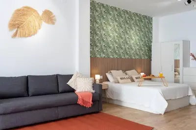 a living room with a couch and a bed at Loft Familiar: Paz y Conexión Ideal en Valencia in Valencia
