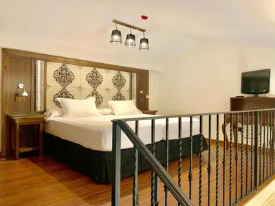 a bedroom with a bed with white sheets and a television at Alqueria de Vilches in Cullera