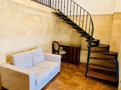 a living room with a couch and a staircase at Alqueria de Vilches in Cullera