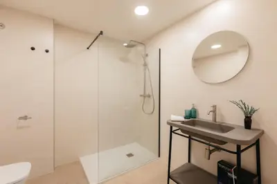 a bathroom with a shower and a sink and a mirror at Doce de Colón Requena in Requena