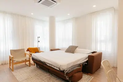 a bedroom with a bed in a room with windows at Doce de Colón Requena in Requena
