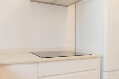 a kitchen with white cabinets and a glass counter top at Doce de Colón Requena in Requena