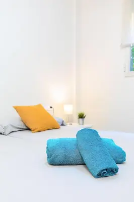 a bed with two blue towels on top of it at Beachside Apartment Valencia Ideal for Digital Nomads in Valencia