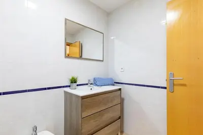 a bathroom with a sink and a mirror and a toilet at Beachside Apartment Valencia Ideal for Digital Nomads in Valencia