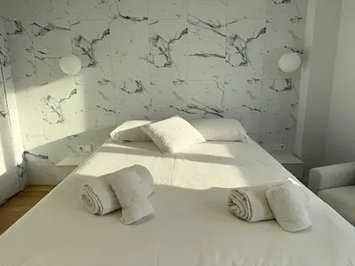 a bedroom with a white bed with towels on it at Design and style next to Playa de Valencia in Valencia