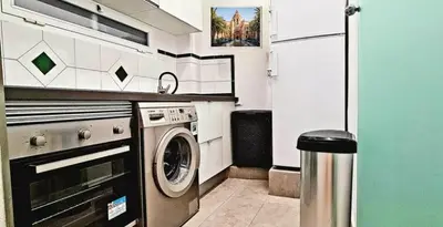 a small kitchen with a washing machine in it at The Plaza Residence in Valencia