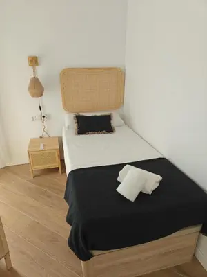 a bedroom with a large bed with a black blanket at Eliving - Apartment BioPark City Center & Airport in Valencia