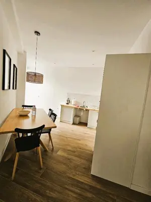 a living room with a table and a kitchen at Eliving - Apartment BioPark City Center & Airport in Valencia