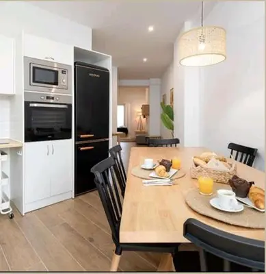a kitchen and dining room with a wooden table with chairs at Eliving - Apartment BioPark City Center & Airport in Valencia
