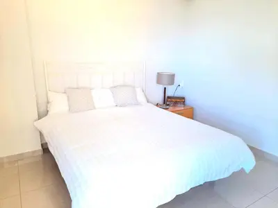 a bedroom with a white bed and a lamp on a table at BEACH VALENCIA LUXURY D15-21 Apartment with terrace and sea views with two rooms in Valencia
